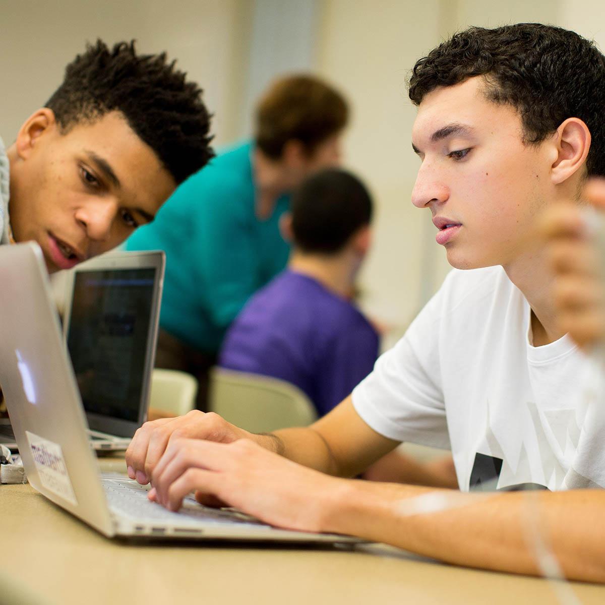 Photo of students working on a laptop together in the classroom